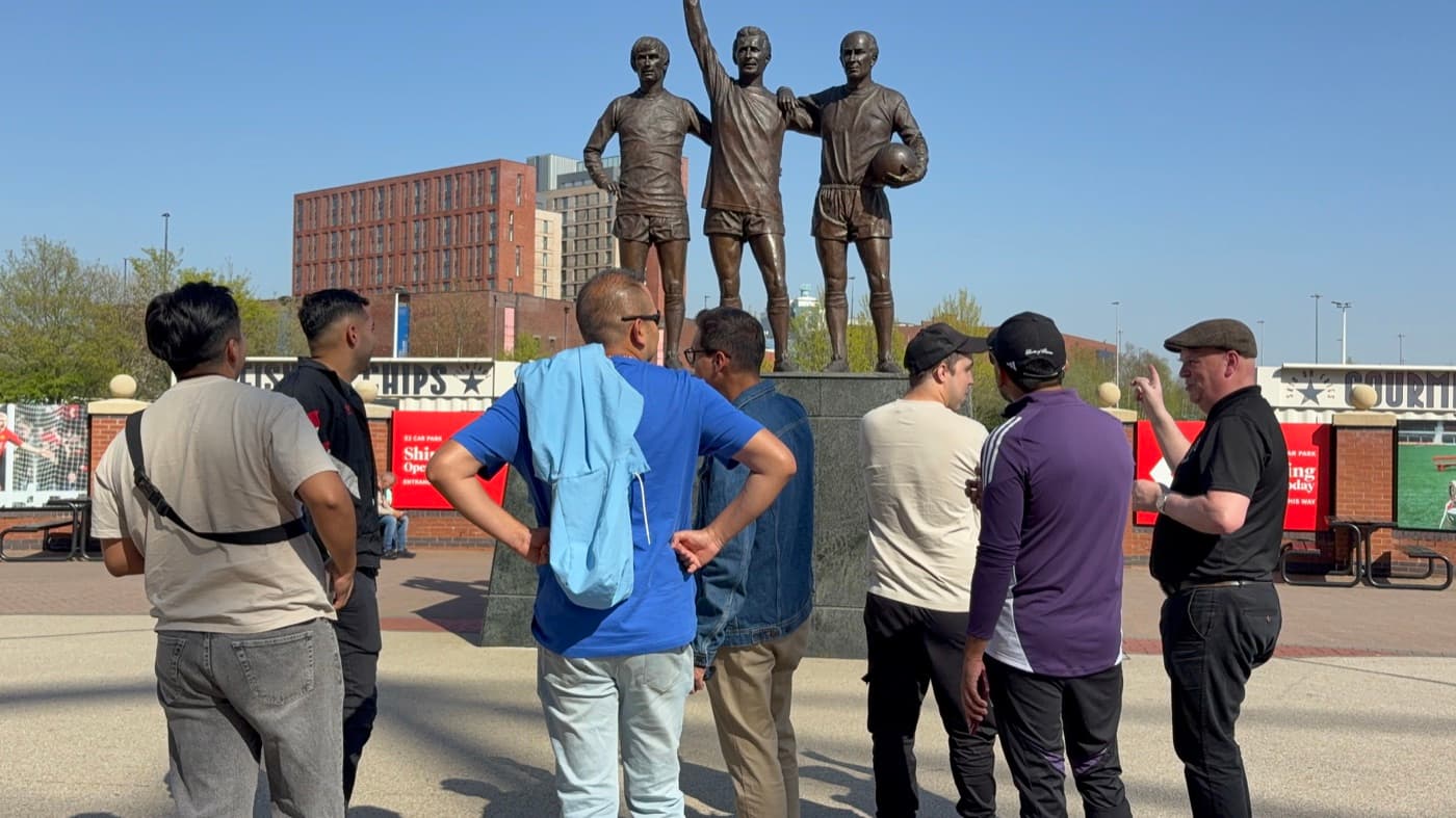 Viajeros de la edición abril 2026 frente a la estatua United Trinity